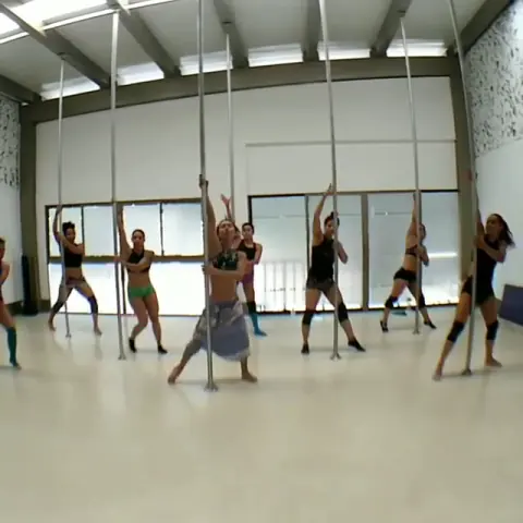 Clase grupal de pole en el salón