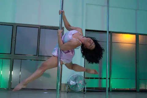 Bailarina girando en la barra con luces verdes