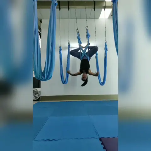 Clase de yoga aéreo con hamacas azules